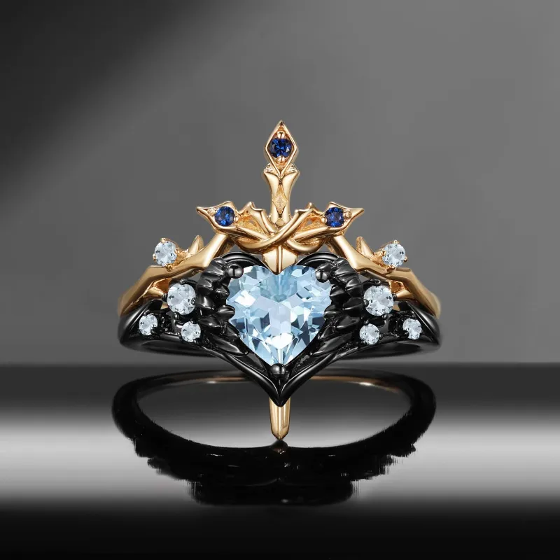 Starlandus Pierced Heart Gothic Inspired Natural Aquamarine Heart Sword Ring Two-Tone Bridal Set showing feather wrapped heart ring with mat