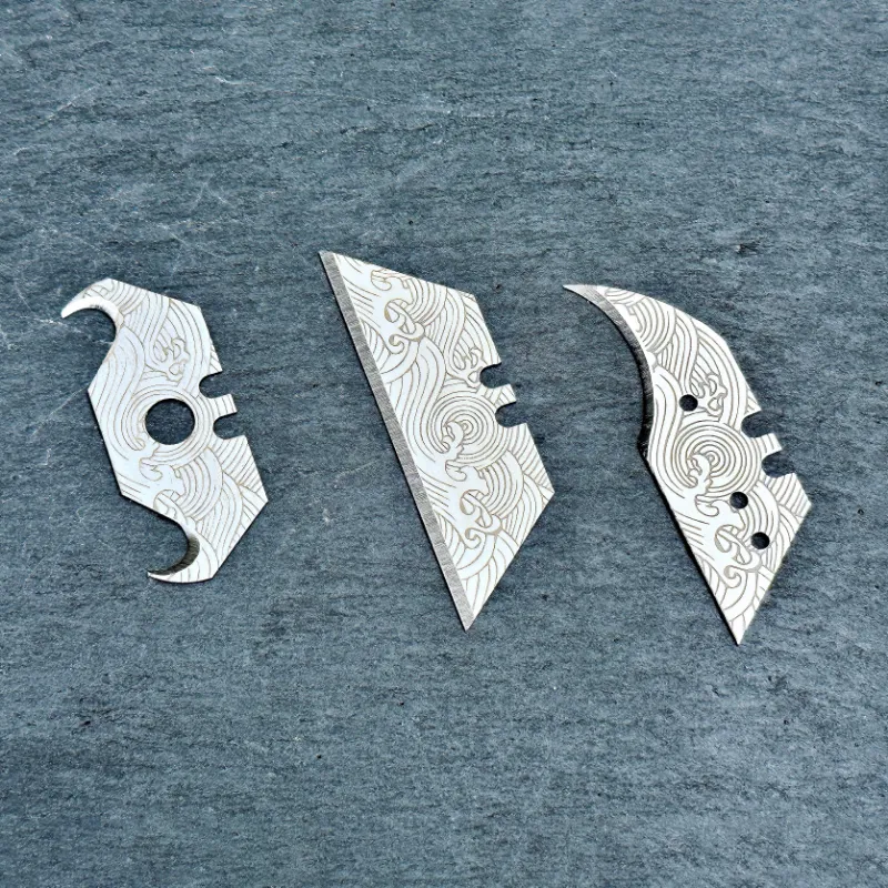 The Stinger Tools laser engraved utility razor blades with ocean wave pattern, three-pack showing trapezoid, concave, and hook blade styles