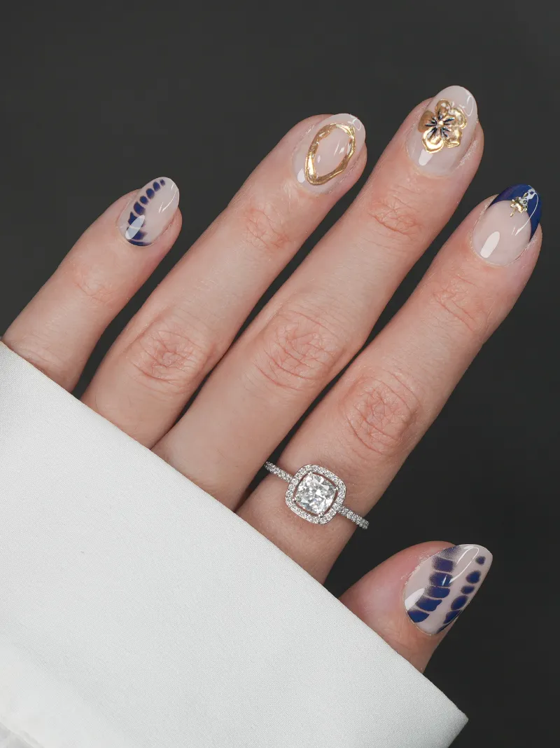 Roxy Nails Paris Aphrodite press-on nails with navy blue art, gold accents, and 3D floral jewel