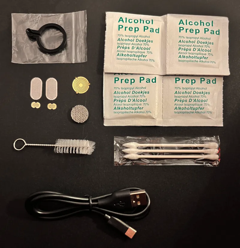Airvape Cleaning Kit for the Legacy 1st Edition with brush, screens, and charger laid out