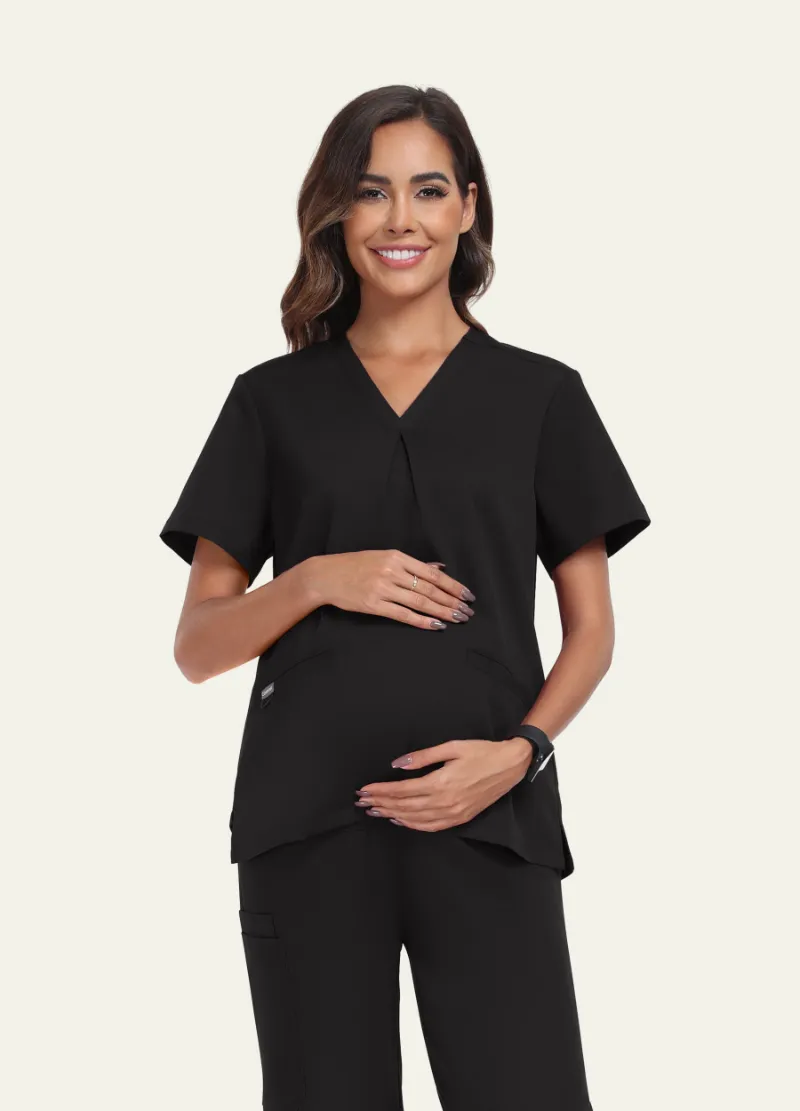 COMENII SoftTouch Maternity Scrub Top in Black, front view showing cross-pleat detail and pocket placement