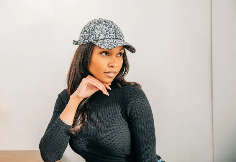 Embellished snakeskin cap with purple satin lining and curved brim