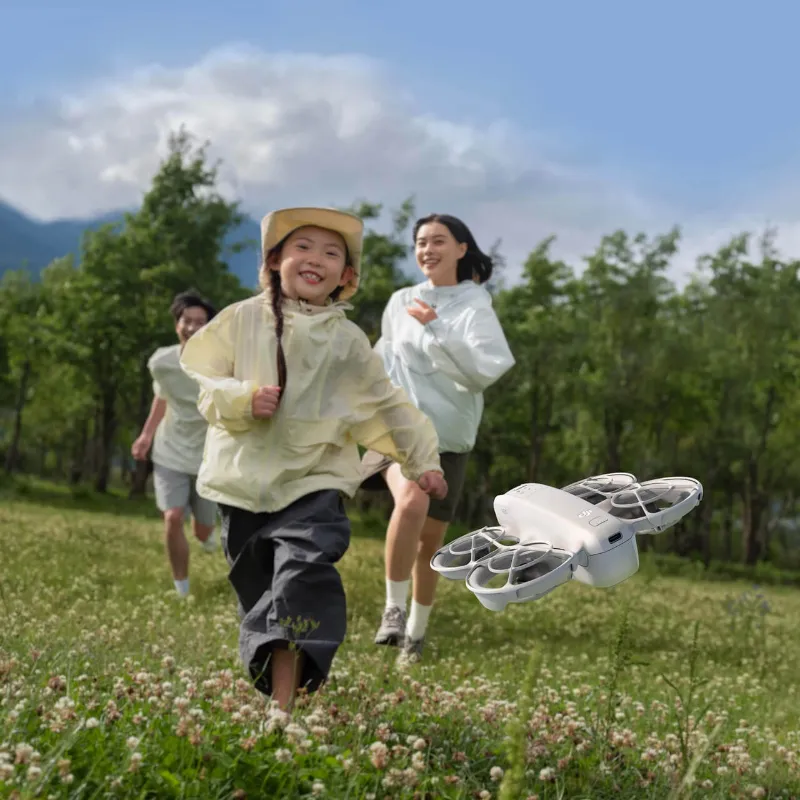 DJI drones Neo, ultra-compact white drone with propeller guards in hand
