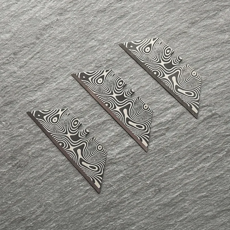 The Stinger Tools Stinger laser engraved utility razor blades black Damascus style trapezoid 3 pack