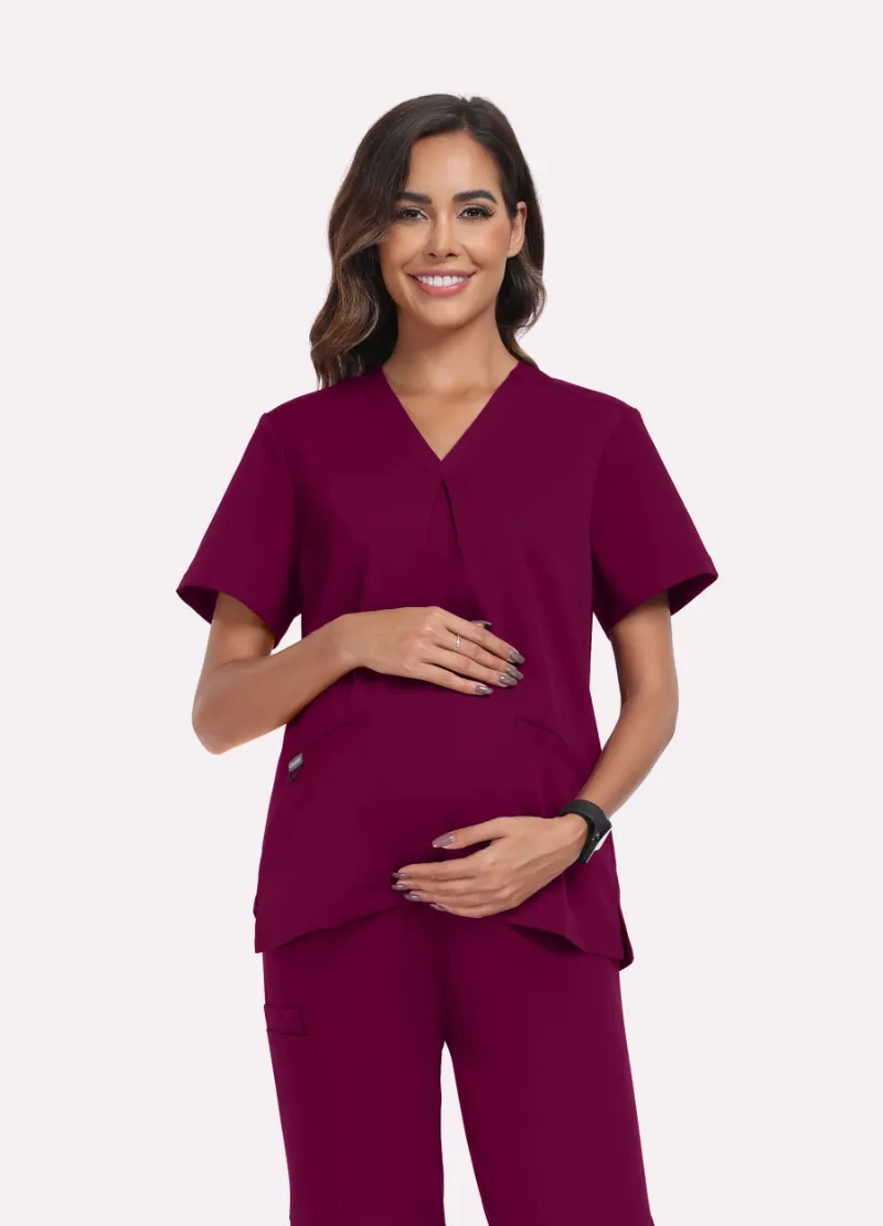 COMENII SoftTouch Maternity Scrub Top in Wine Red, front view showing cross-pleat detail and pocket placement
