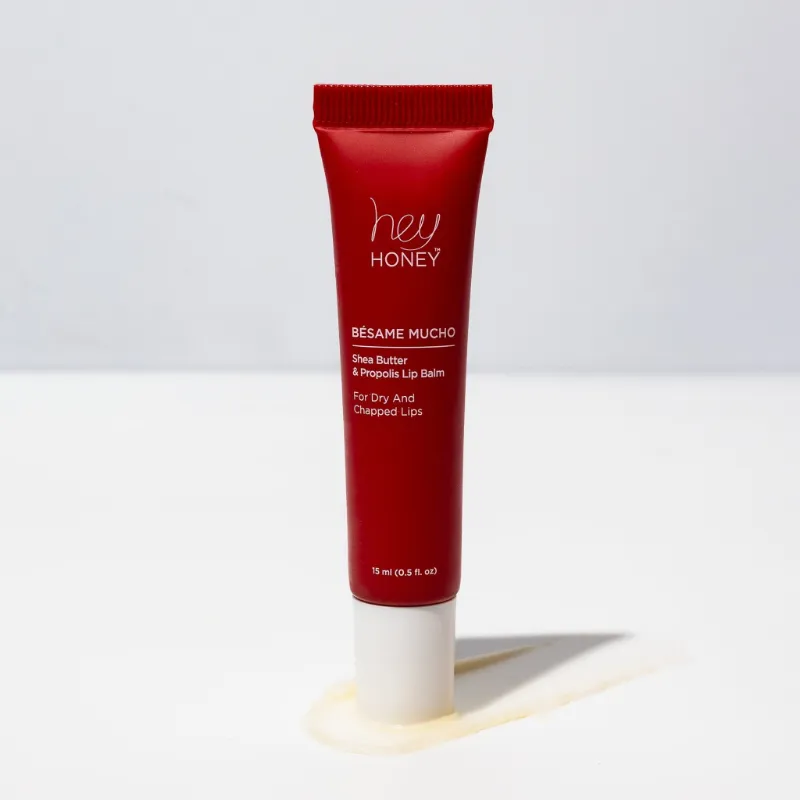 Hey Honey BÉSAME MUCHO Shea Butter & Propolis Lip Balm tube on neutral surface