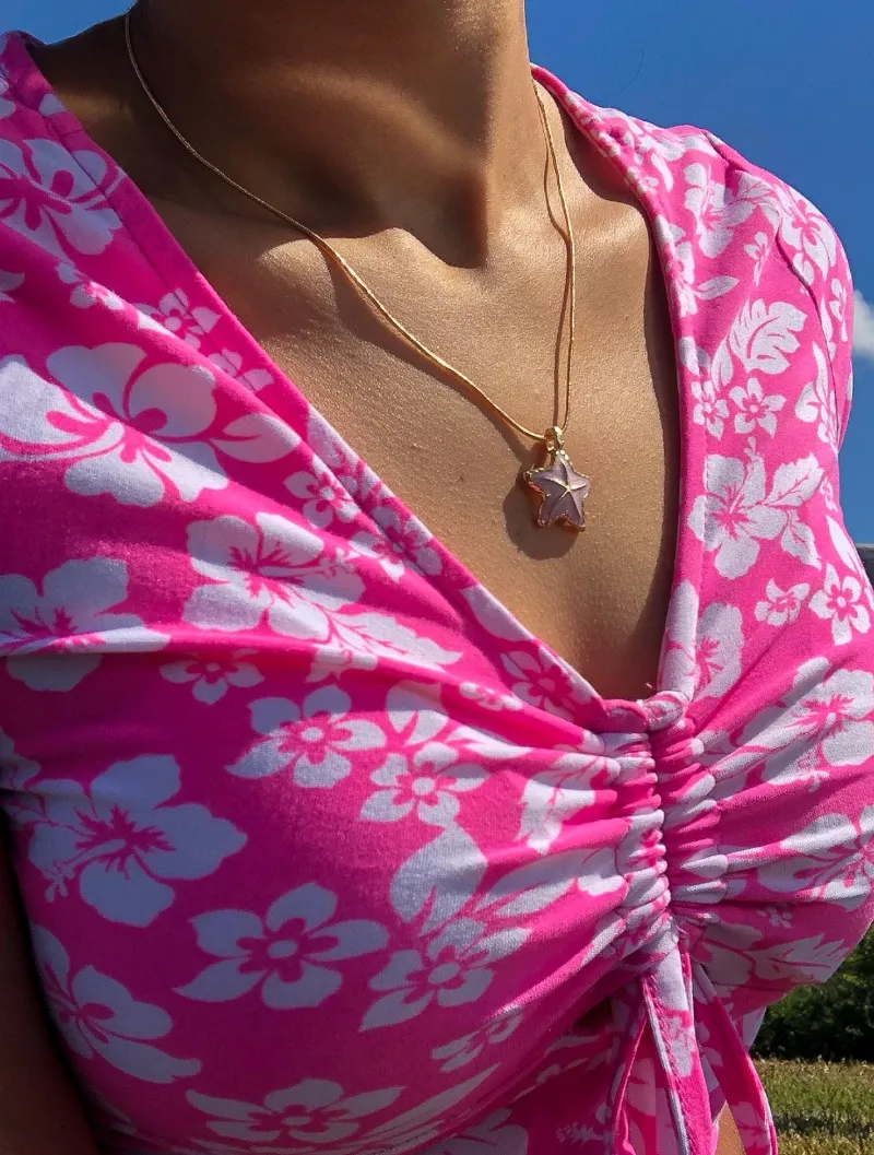 Bit By Angie Brielle necklace showing a pink and gold starfish charm on a chain