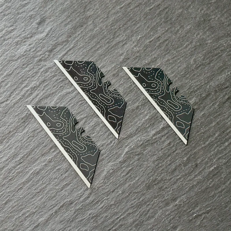 The Stinger Tools Stinger laser engraved utility razor blades black topographic style trapezoid 3 pack