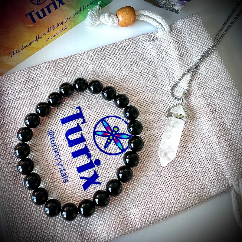 Turix Energy Protection Pairing showing Black Onyx bracelet and Clear Quartz crystal point pendant necklace