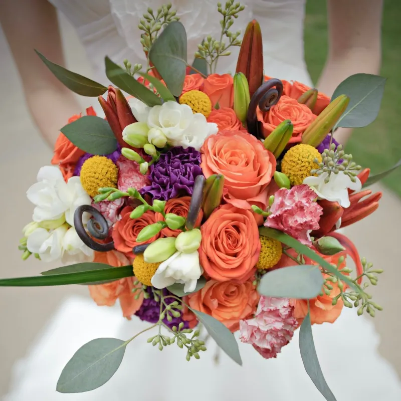 Flower Boom Dallas Brightness colorful bridal bouquet with orange, yellow, purple, and green blooms