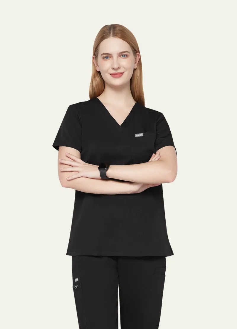 COMENII ProEase™ Basic Scrub Top in Black, front view showing chest pocket and tailored silhouette