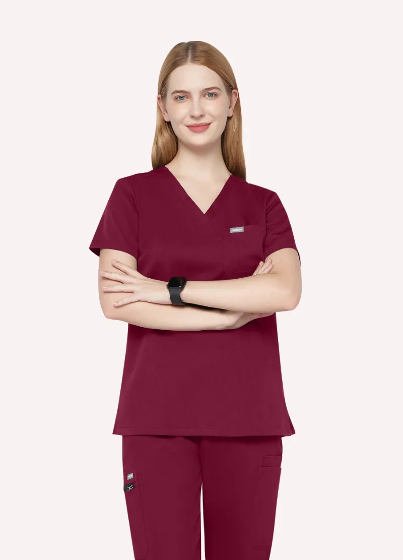 COMENII ProEase™ Basic Scrub Top in Burgundy, front view showing chest pocket and tailored silhouette