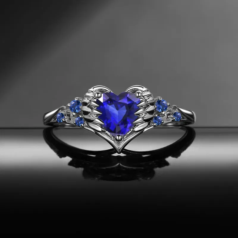 Starlandus Pierced Heart Gothic Lab Sapphire Heart & Sword Engagement Ring with Angel Wing Detail showing feather and wing wrapped heart wit