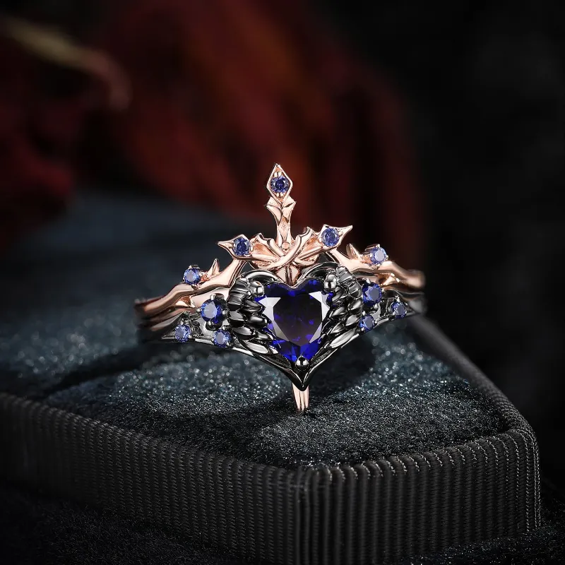 Starlandus Pierced Heart Gothic Inspired Lab Sapphire Heart Sword Ring Two-Tone Bridal Set showing feather wrapped heart ring with matching 
