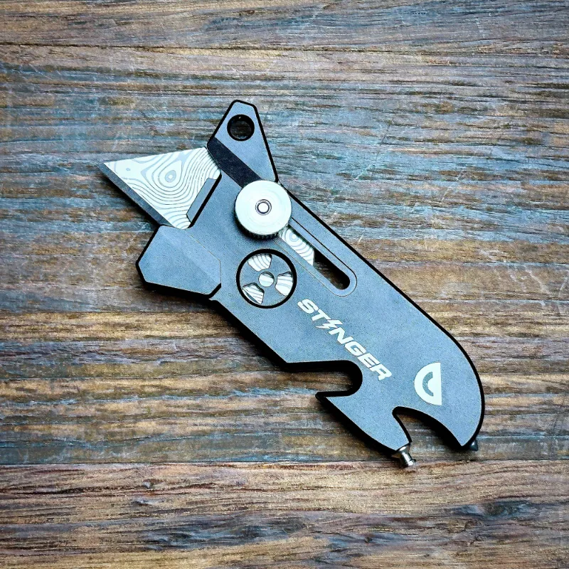 The Stinger Tools Stinger EDC Blade keychain utility knife in matte black showing bottle opener and breaker features
