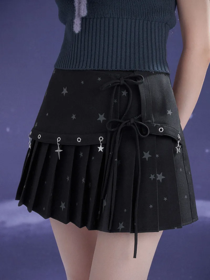 Juwas Black Star Charm Bow Pleated Mini Skirt showing the black pleated skirt with front bow and dangling star accessory.