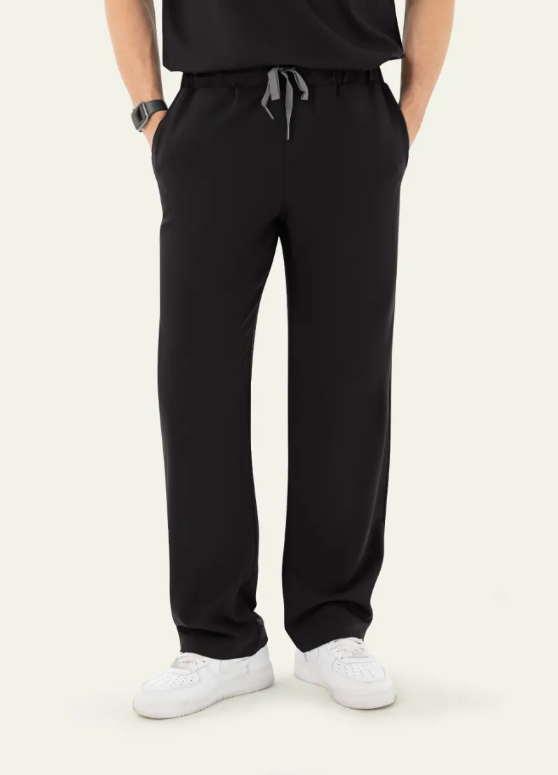 COMENII DynaComfort™ Essential Scrub Pant in Black shown full-length, highlighting the straight-leg fit and pocket placement