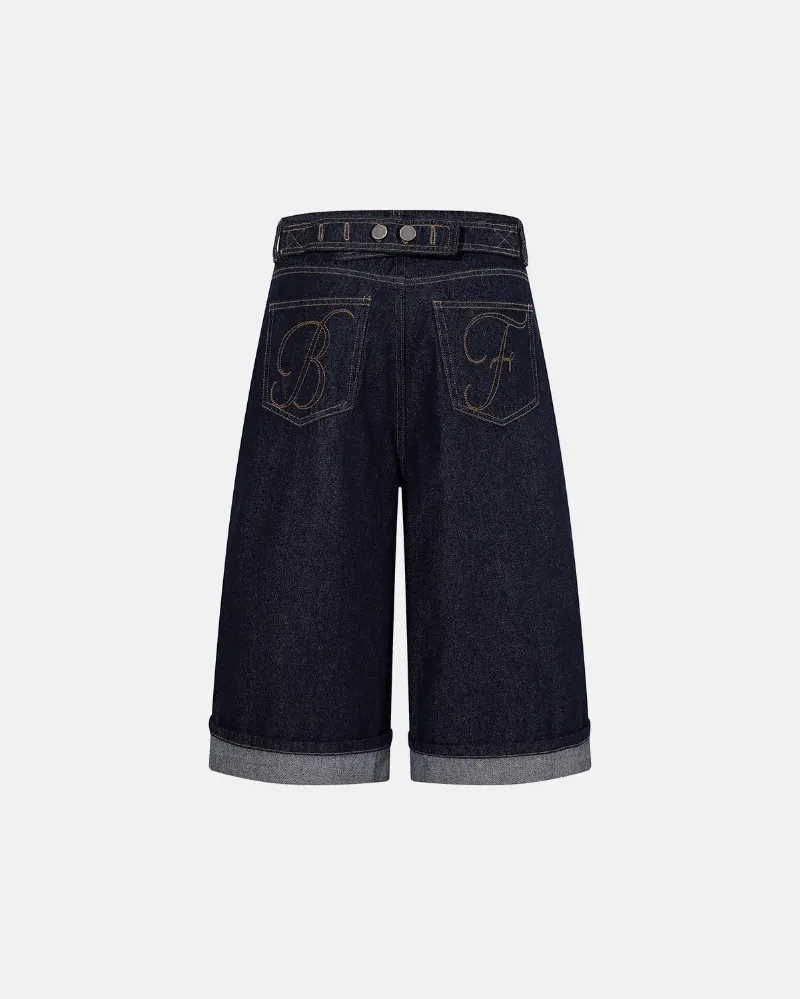INFLATION Cinch Back Baggy Denim Jorts in raw blue with adjustable back buckle and embroidered pockets